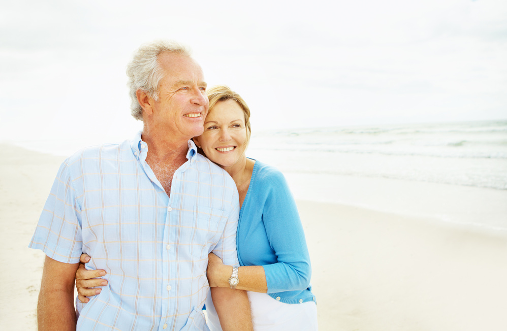 Sweet picture of older couple embracing on a beach
